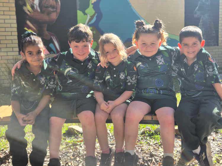 Kindy students sitting on a fence