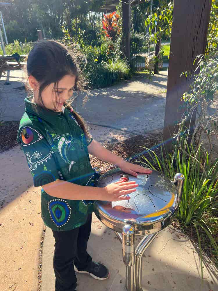 Student on excursion playing outdoor drum